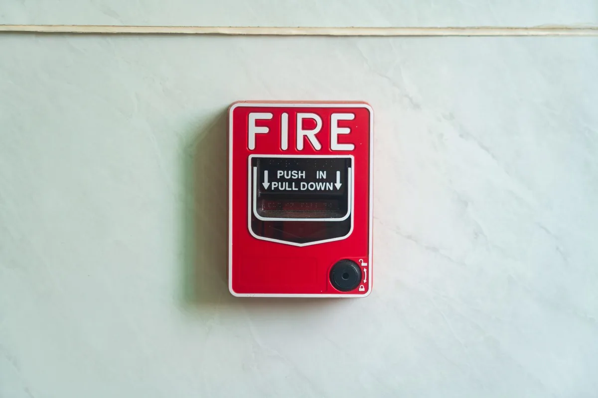 HMO hallway showing a self-closing FD30 fire door and interlinked smoke alarm